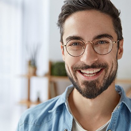 Man with glasses and beard smiling 