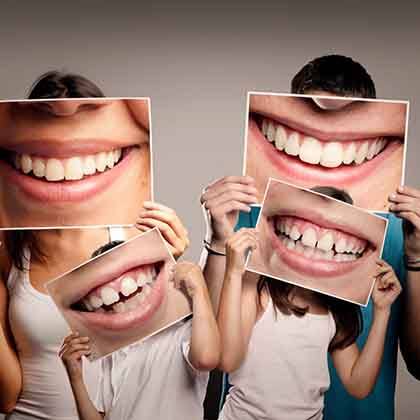 Family holding large pictures of their smiles