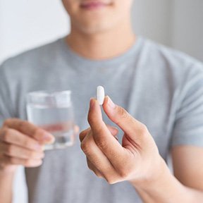 a person taking an oral conscious sedation pill