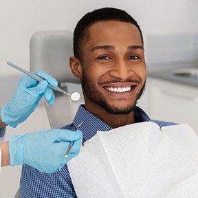 a patient smiling while undergoing a dental checkup