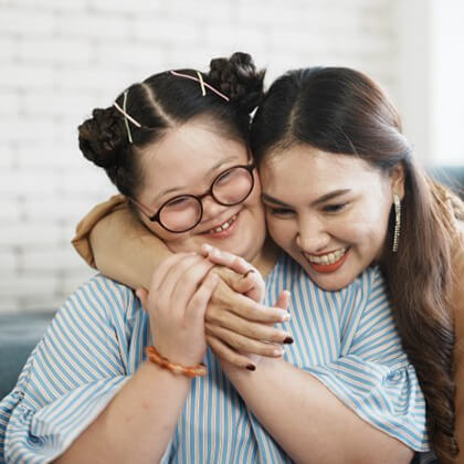 a mother and her special needs daughter smiling